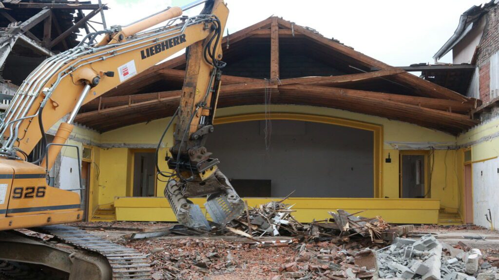 Pelleteuse Liebherr en action lors de la démolition d’une maison en zone habitée à Genève – chantier JD Dusonchet
