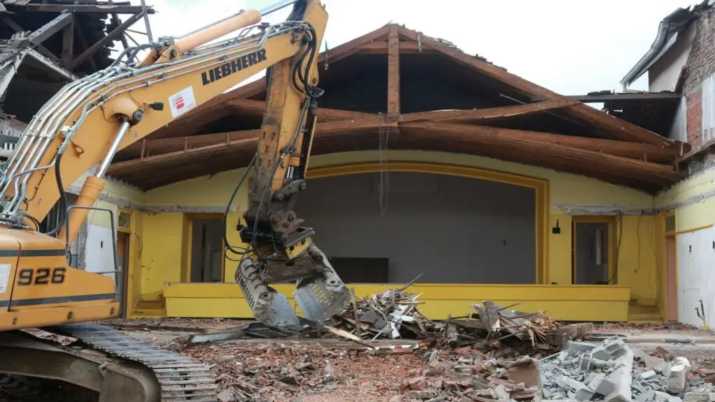 Pelleteuse Liebherr en action lors de la démolition d’une maison en zone habitée à Genève – chantier JD Dusonchet