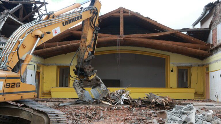 Pelleteuse Liebherr en action lors de la démolition d’une maison en zone habitée à Genève – chantier JD Dusonchet